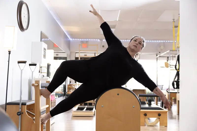 beginner-pilates-session Woman performing an exercise on ladder barrel in a fully equipped Pilates studio in Stuart Fl